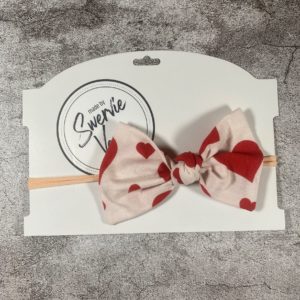 White and pink knotted fabric bow on nylon headband