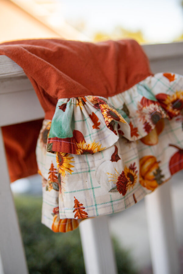 White ruffle with pumpkins outside