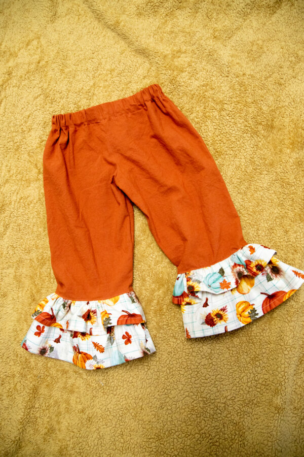 Orange pants with white Fall fabric ruffles. 2 ruffles at the bottom of the pants